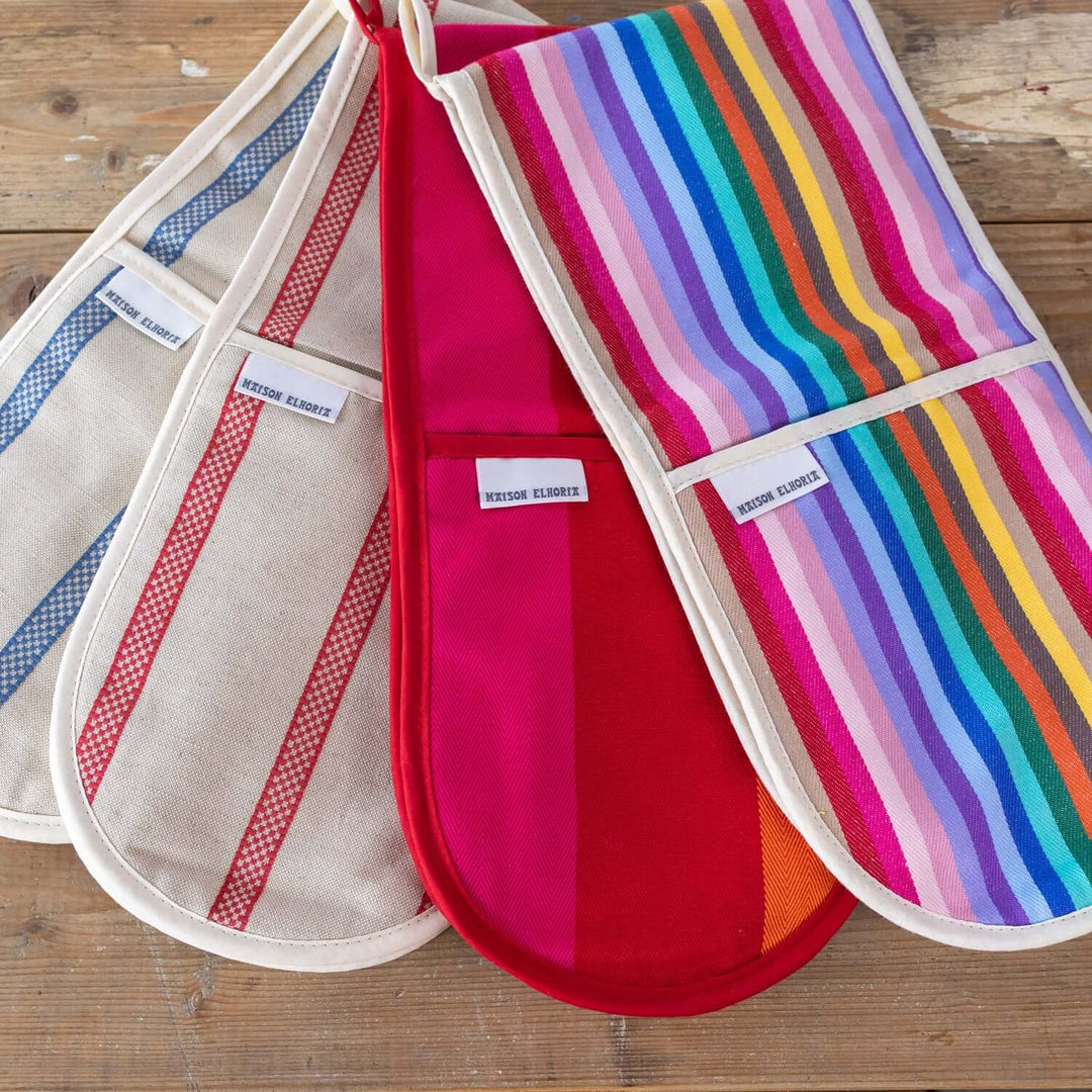 4 double oven gloves on a wooden table close up