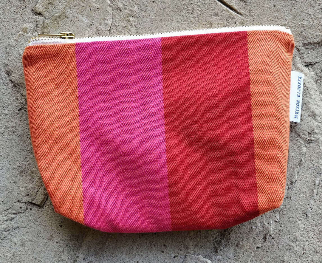 Toiletry bag red orange pink with a metal zip flat close up photo