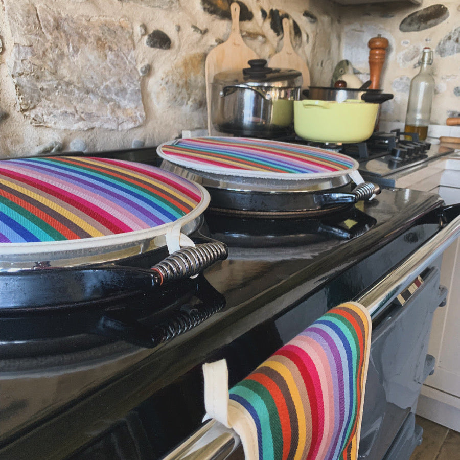Kitchen \Aga cooker with a pair of rainbow Aga hob covers and a matching double oven glove hanging