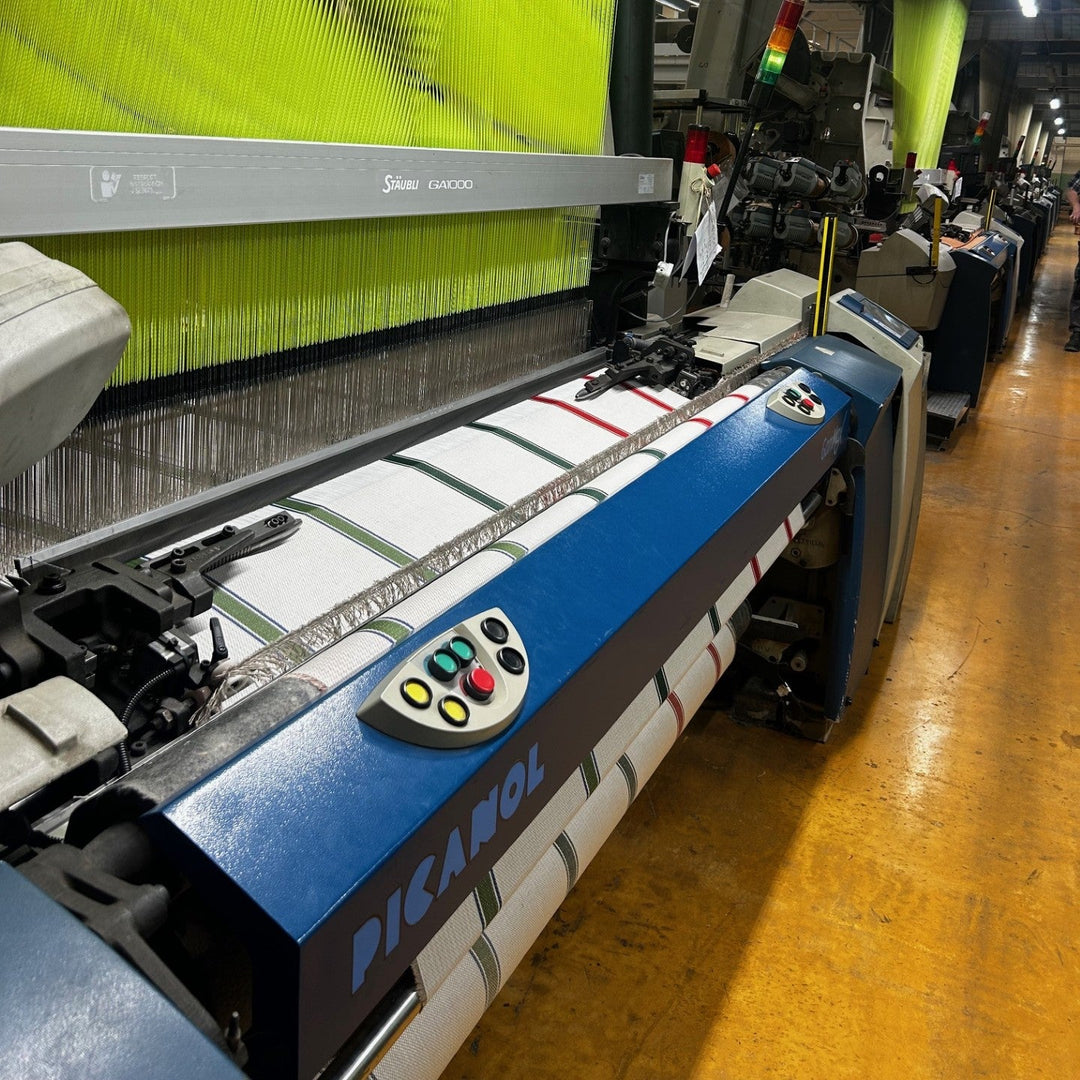 Textile machine with green and red fabric in a factory setting