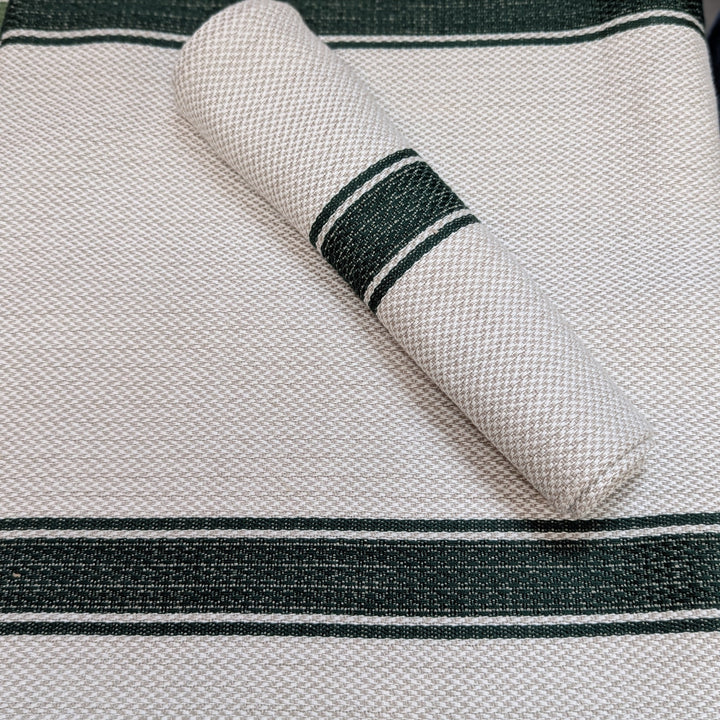 Rolled-up napkin with green stripes on a textured surface