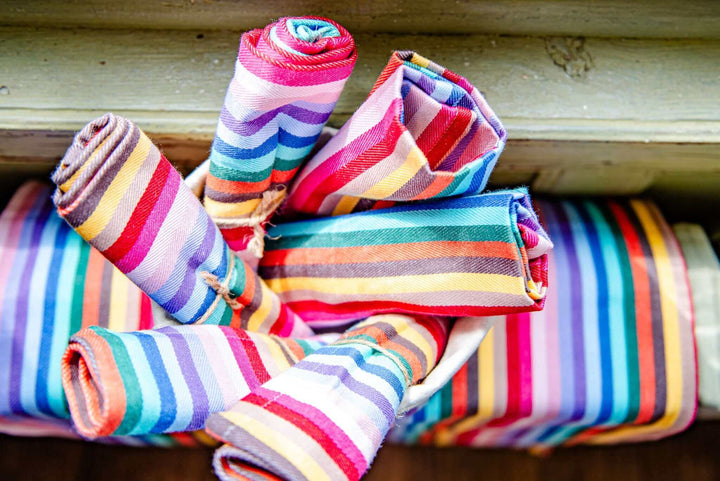 Rainbow napkins cotton rolled up on a rainbow pot bag