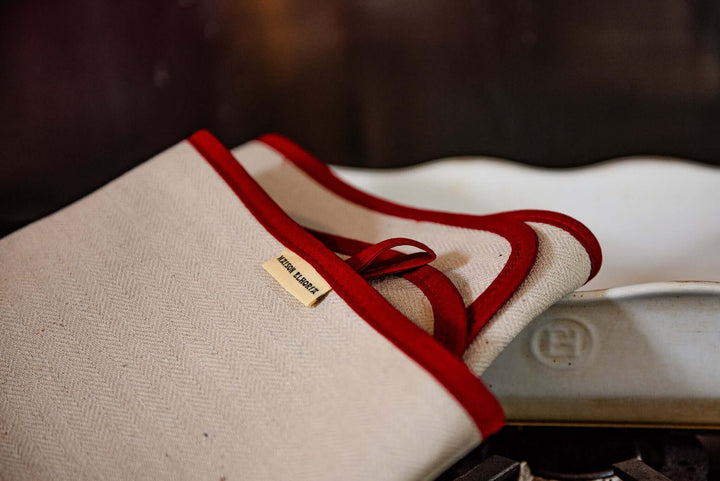 oven cloth with red edges folded over white oven dish