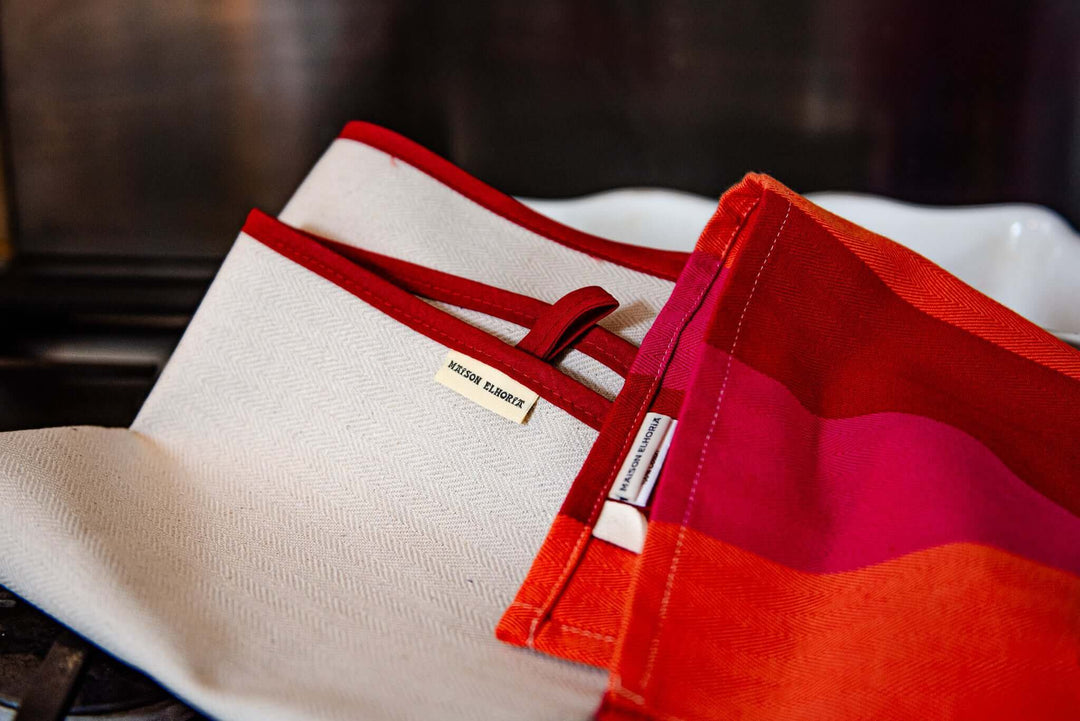 Oven cloth natural with red bias folded with red orange pink tea towel close up