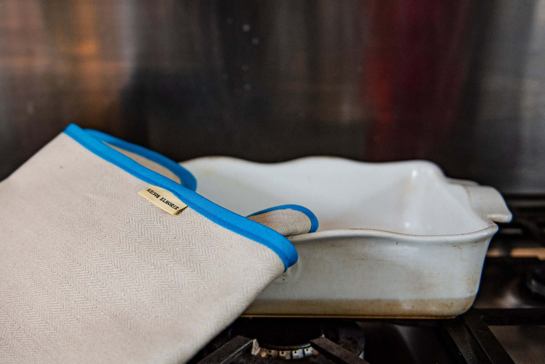oven cloth with light blue edge close up on an oven serving dish white