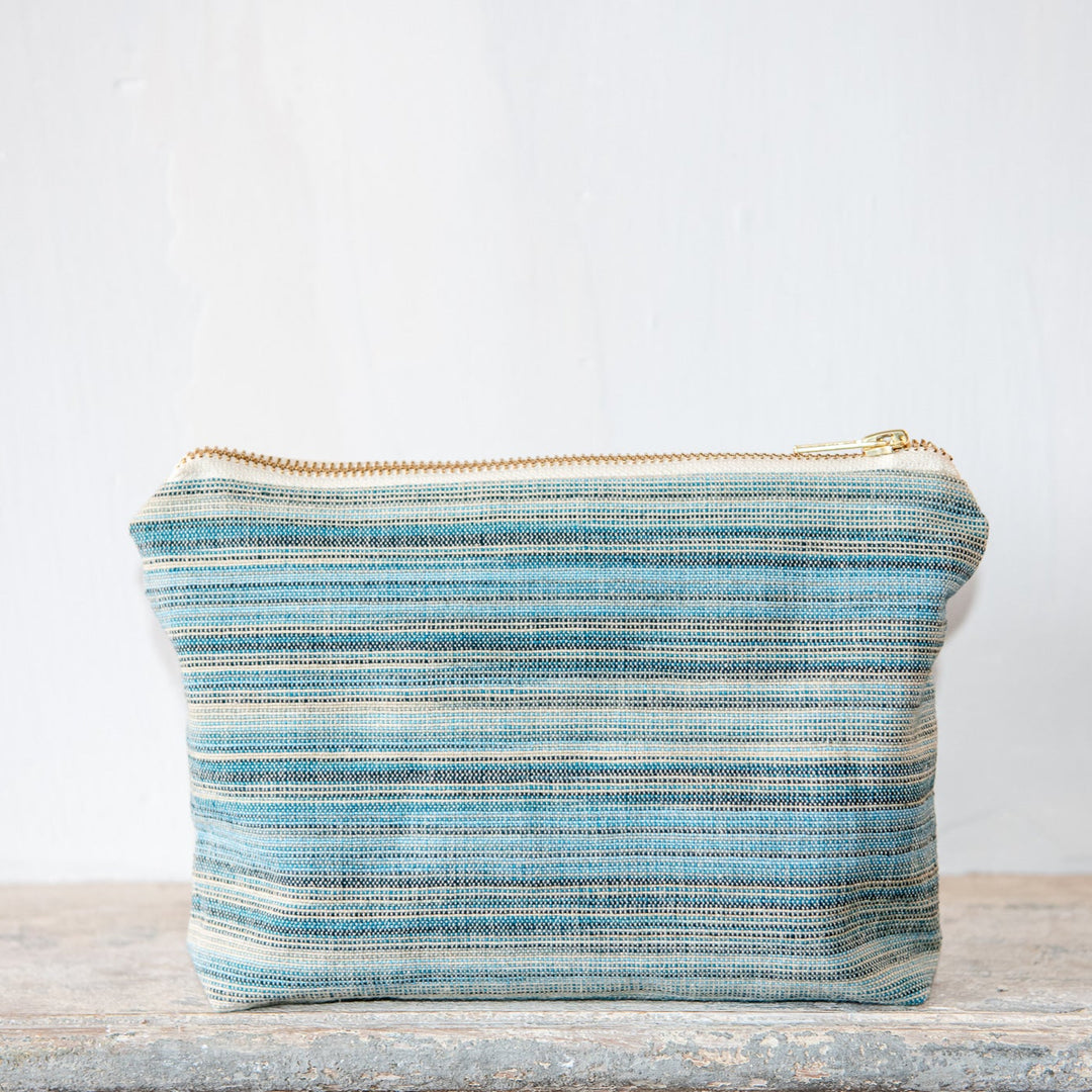 Toiletry wash bag blue and beige on a sone base with plain white background