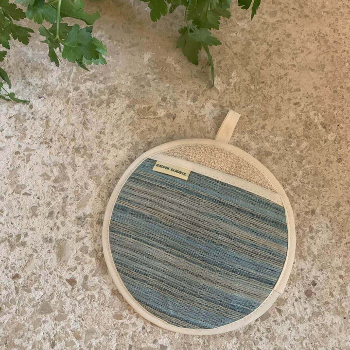 Pot grab blue striped and round flat on off white surface