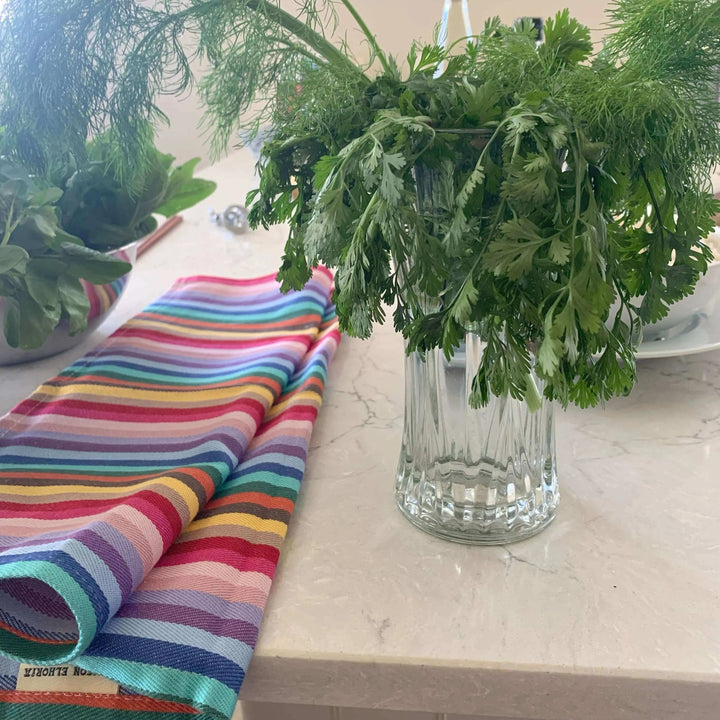 Tea Towel Rainbow from Maison Elhoria on a marble top white with fresh cooking herbs
