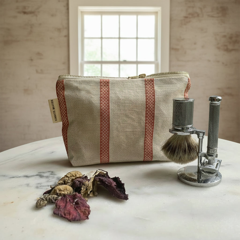 Striped pouch with a shaving brush and razor on a marble surface