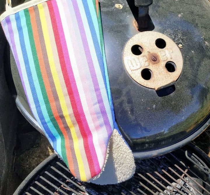 Rainbow snapper gauntlet long oven mitt above an old rusty weber barbeque