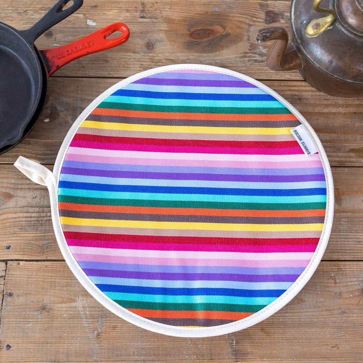 Rainbow striped Aga hob cover on the round chrome lid of an Aga, woven cotton, made in Britain