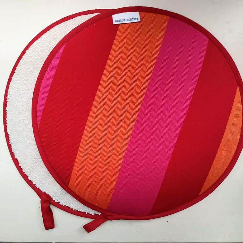 Pair of red orange pink striped Aga hob covers on both round chrome lids of an Aga range cooker, woven cotton, made in Britain
