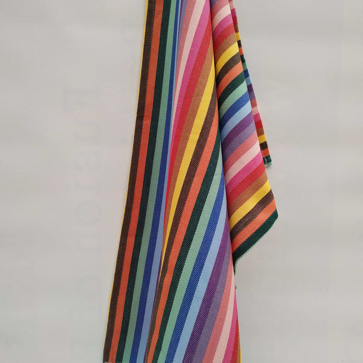 rainbow kitchen towel hanging off a plain off white wall