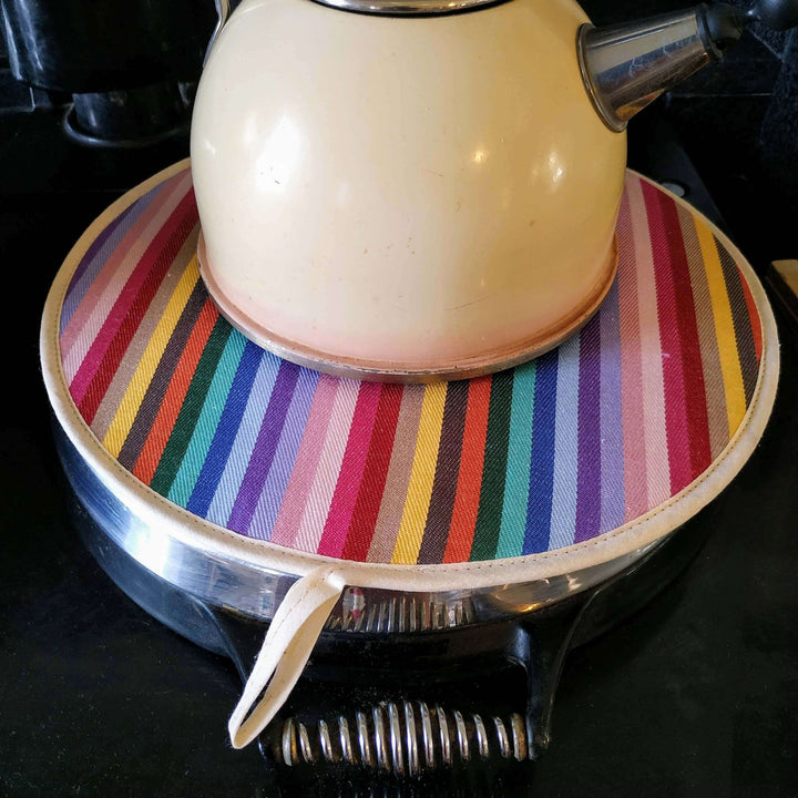 Rainbow premium quality insulating Aga hob plate cover on Aga hob plate cover with a beige metal kettle on it