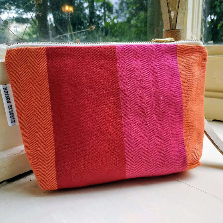 red orange pink wash bag on a window seal
