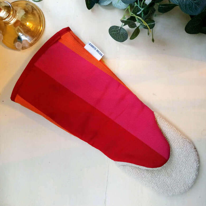 Gauntlet long oven glove red orange pink organic cotton  white background lamp base  and some green leaves
