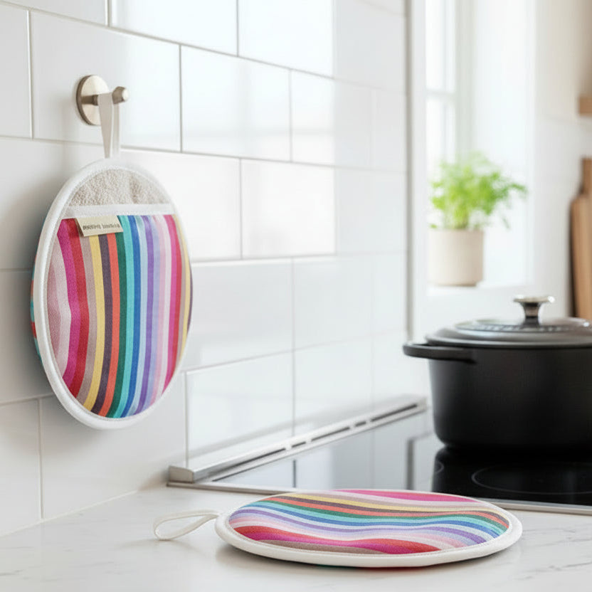 A pair Rainbow round pot holder or pot  grabber type oven mitt on a white marble counter